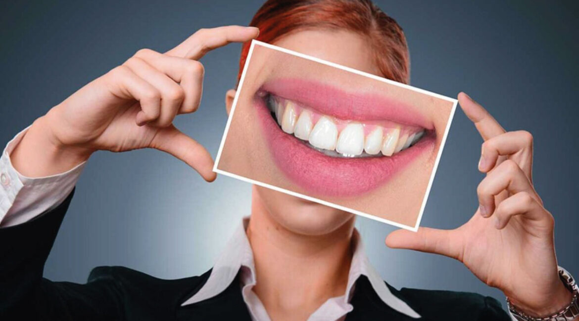 Close-up of a smiling young woman with healthy, white teeth and bright pink lips, showcasing a radiant and confident smile, indicative of good dental health